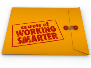 The image shows a yellow envelope with a red clasp, slightly opened, with the words "Secrets of WORKING SMARTER" printed boldly on the front in red, distressed text. The design gives the impression that the envelope contains valuable, insider tips or strategies on how to increase productivity by working more efficiently.