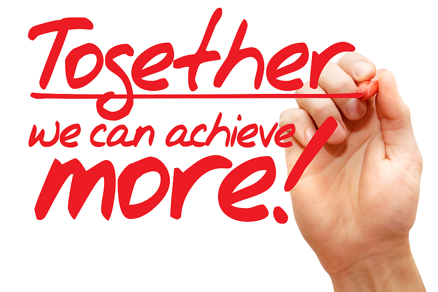 ALT text: A hand writing the motivational phrase "Together we can achieve more!" in red marker, emphasizing the power of teamwork and collaboration to reach greater success.