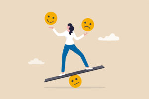 Illustration of a woman balancing on a seesaw with a neutral face emoji beneath her feet, holding a happy face emoji in one hand and a sad face emoji in the other. The background is light beige with simple cloud illustrations, symbolizing emotional balance and resilience.