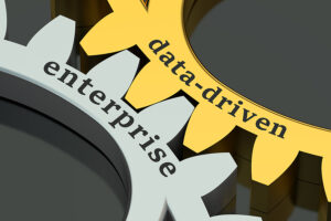 **Alt Text:** Two interlocking gears labeled "data-driven" and "enterprise," symbolizing the integration of data-driven decision-making within an organization. The "data-driven" gear is gold, while the "enterprise" gear is silver, representing a cohesive approach to business strategy through data insights.