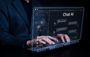 Alt text: A person in a dark suit typing on a keyboard with a futuristic, transparent screen displaying a chatbot interface labeled "Chat AI." The interface shows conversation icons, input text fields, and options such as "Clear," "Light mode," "Updates," and "Log out," highlighting the integration of artificial intelligence in communication and technology